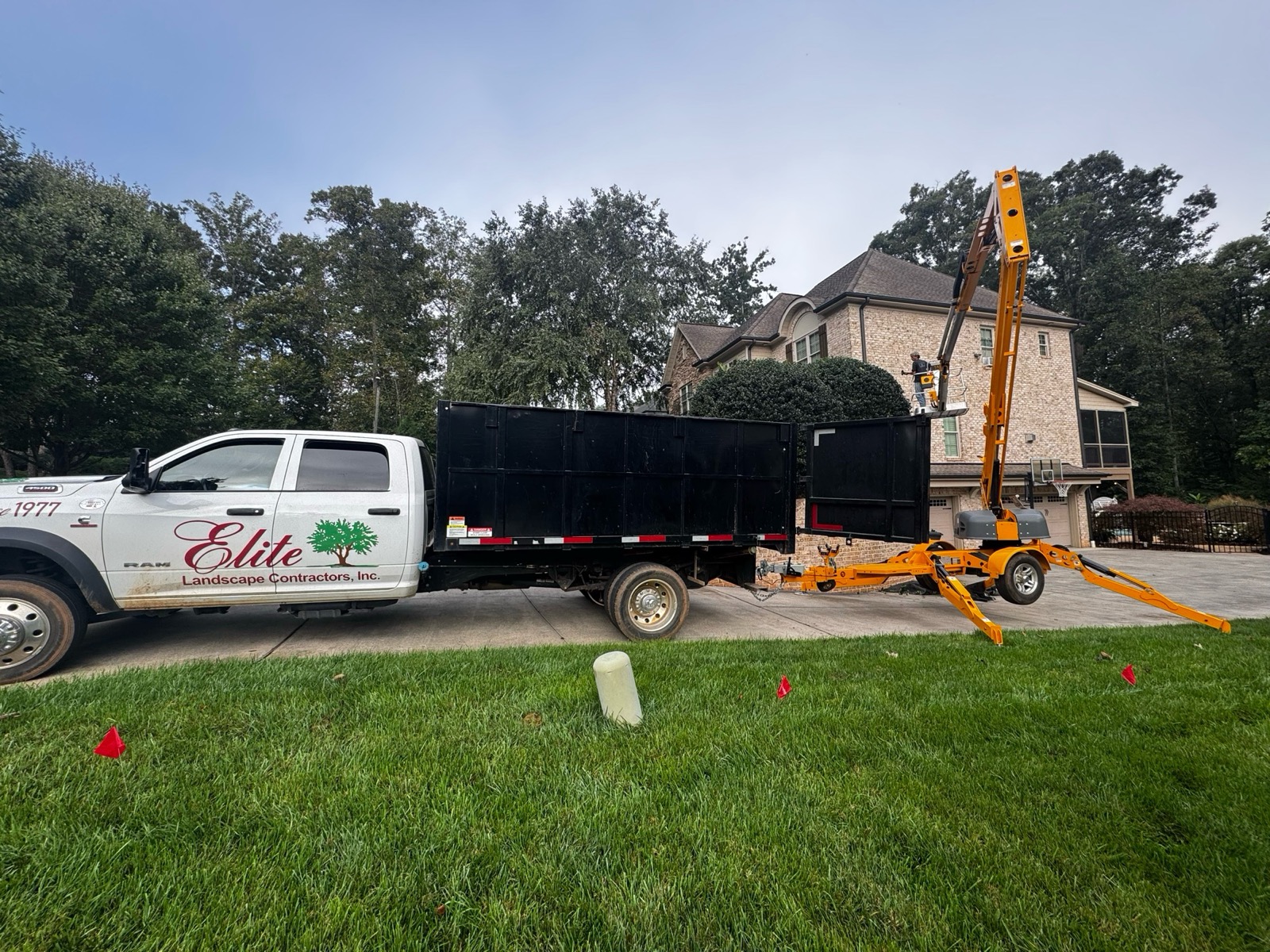 An Elite Landscape Contractors lift crew working at a residential property