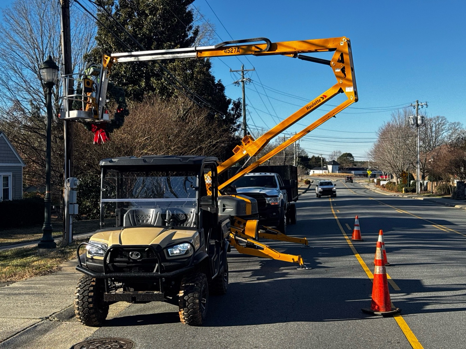 Elite crews using a boom lift for seasonal tree lighting